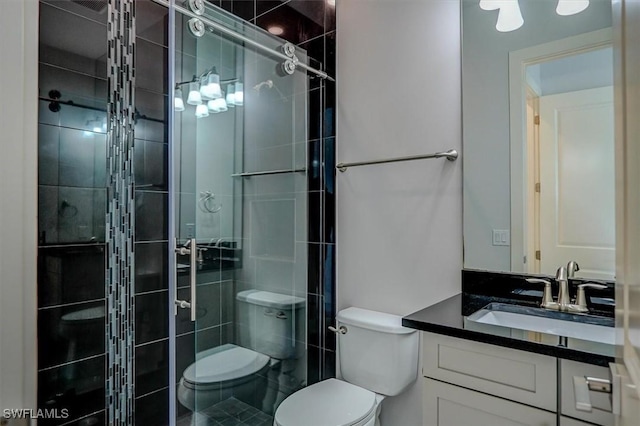 bathroom with a shower with door, vanity, and toilet