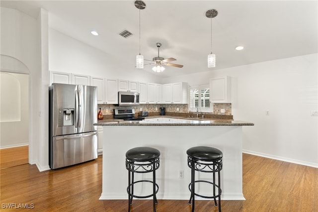 kitchen featuring appliances with stainless steel finishes, backsplash, white cabinetry, and sink