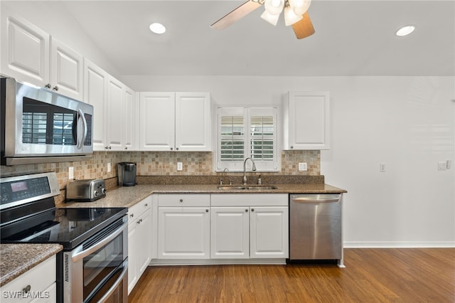 kitchen featuring light wood-type flooring, appliances with stainless steel finishes, sink, and white cabinetry