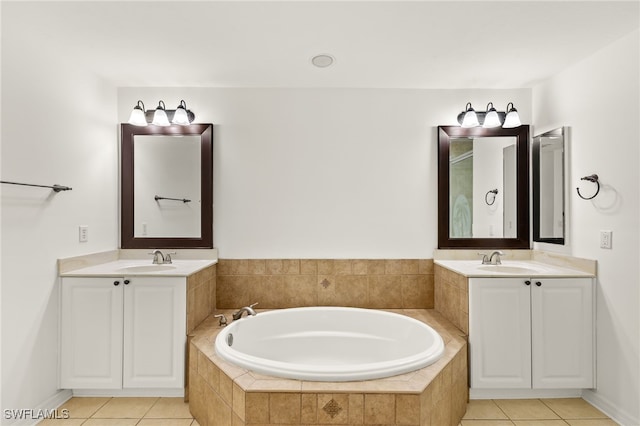 bathroom featuring tiled bath, vanity, and tile patterned flooring