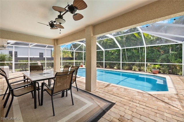 view of swimming pool featuring ceiling fan, glass enclosure, and a patio area