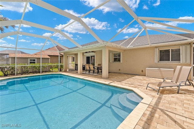 view of pool with a lanai, ceiling fan, and a patio