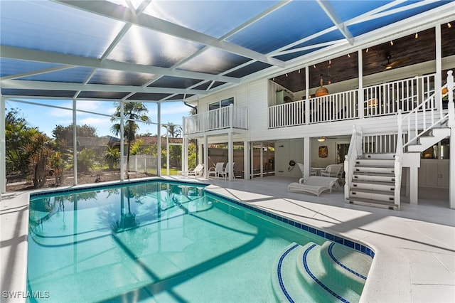 view of swimming pool featuring ceiling fan, a patio area, and glass enclosure