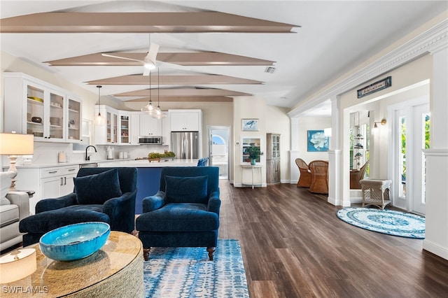 living room featuring vaulted ceiling with beams, dark hardwood / wood-style flooring, and sink