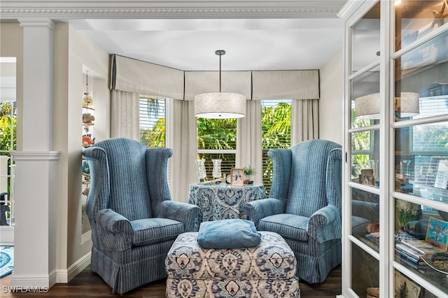 living area with ornate columns, ornamental molding, and dark hardwood / wood-style floors