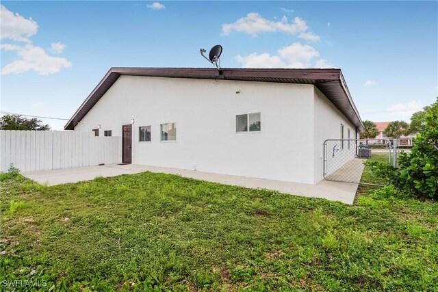 back of house with a yard and a patio area