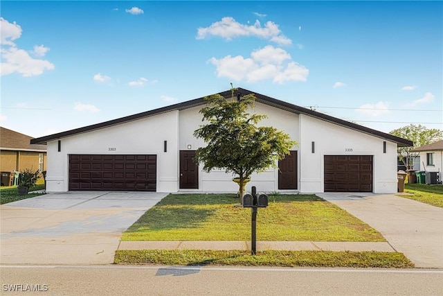 view of front of home with cooling unit, a garage, and a front lawn