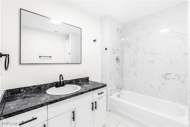 bathroom featuring vanity, tiled shower / bath combo, and tile patterned flooring