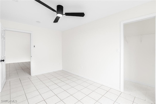 tiled spare room with ceiling fan