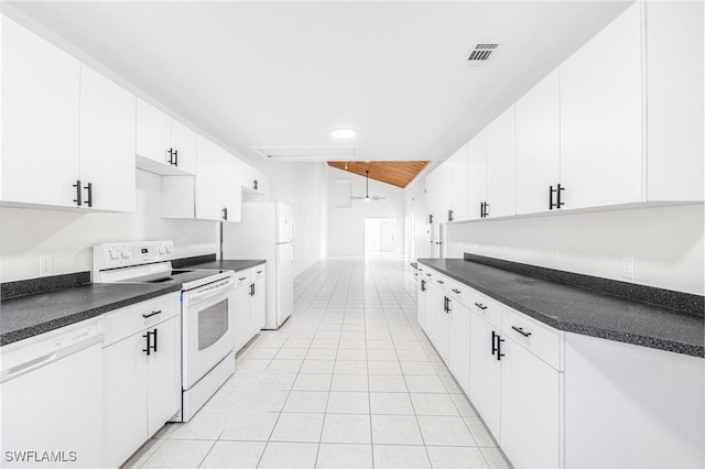 kitchen with light tile patterned flooring, white cabinets, and white appliances