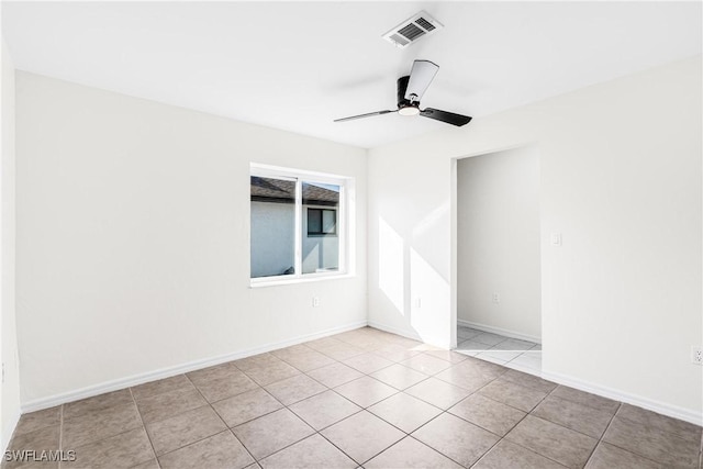 empty room with ceiling fan and light tile patterned floors