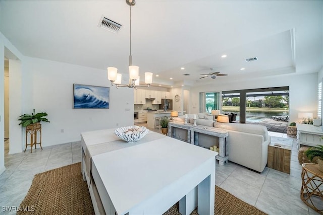 dining room featuring ceiling fan with notable chandelier and light tile patterned floors