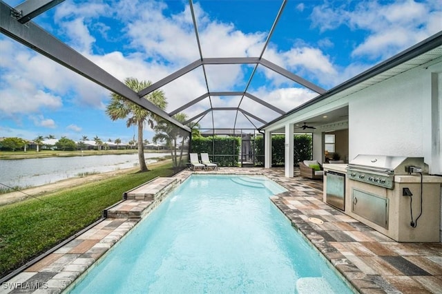 view of swimming pool with a patio area, area for grilling, glass enclosure, a water view, and an outdoor kitchen