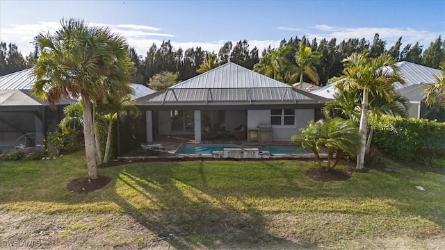 rear view of house featuring a lanai and a yard