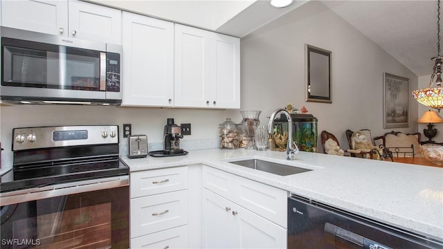 kitchen featuring lofted ceiling, white cabinets, appliances with stainless steel finishes, and sink