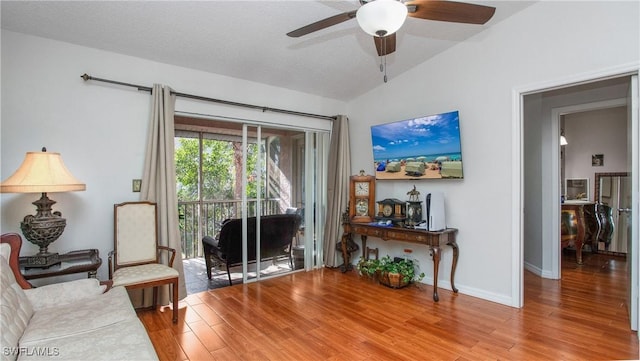 living room with a textured ceiling, ceiling fan, lofted ceiling, and light hardwood / wood-style floors