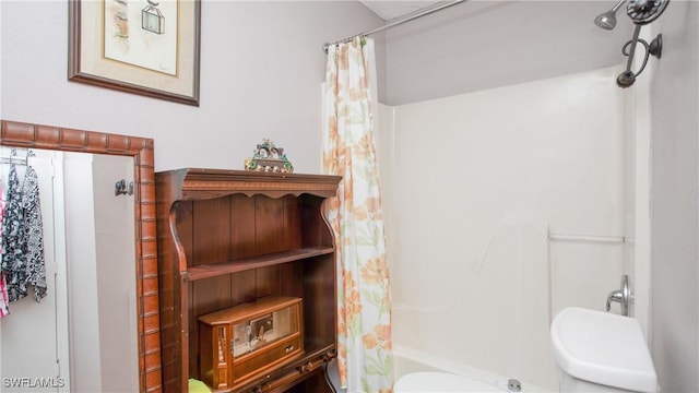 bathroom with shower / bath combo with shower curtain and toilet