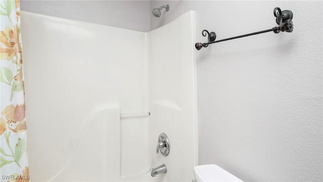 bathroom featuring toilet and shower / bathtub combination with curtain