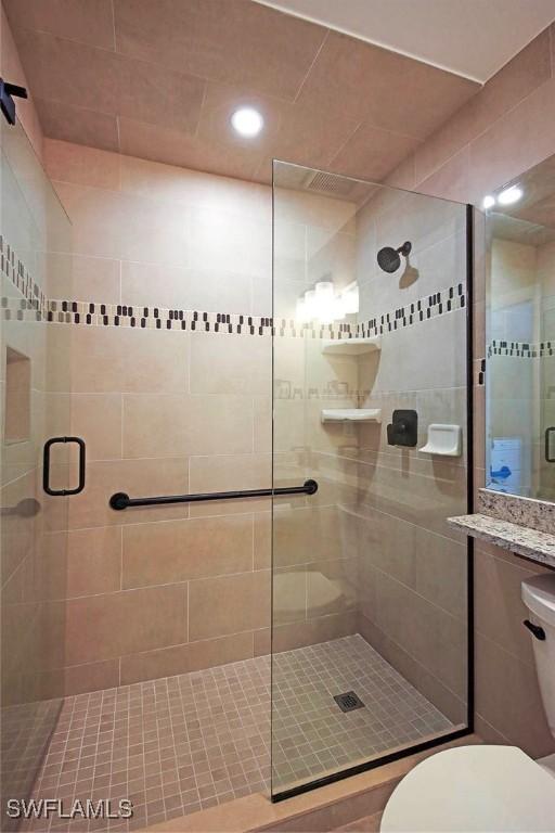 bathroom featuring an enclosed shower and toilet