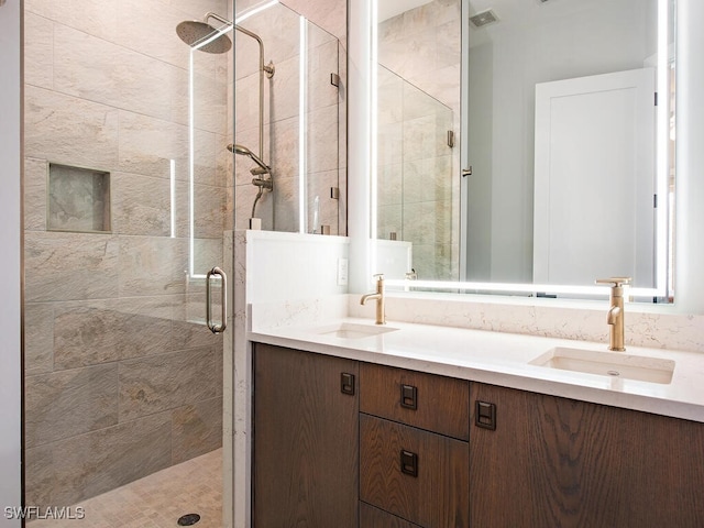 bathroom featuring a shower with door and vanity