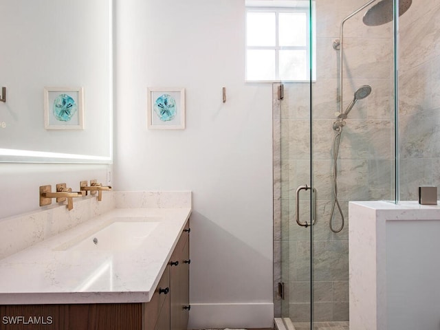 bathroom featuring a shower with shower door and vanity