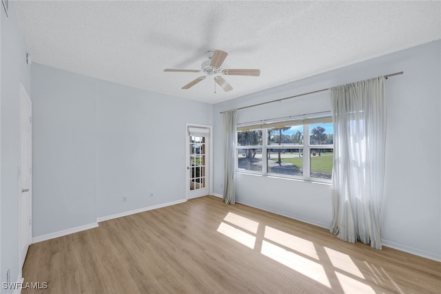 spare room featuring ceiling fan, a textured ceiling, and light wood-type flooring