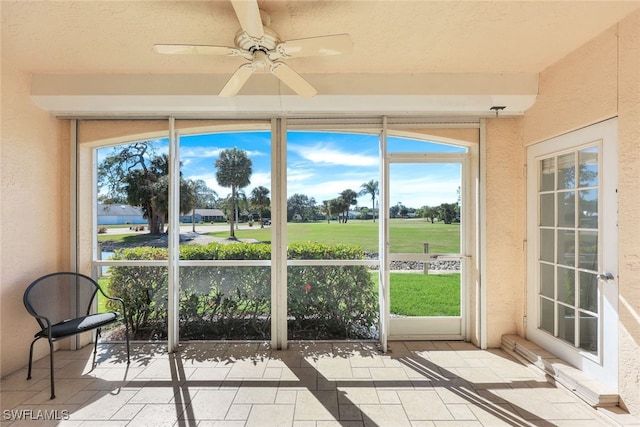 unfurnished sunroom with ceiling fan