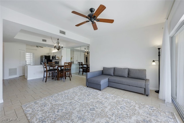 living room featuring ceiling fan with notable chandelier