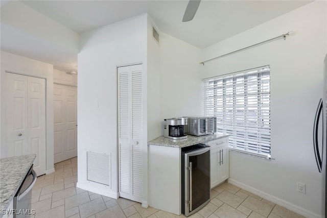 kitchen featuring white cabinetry, beverage cooler, and ceiling fan