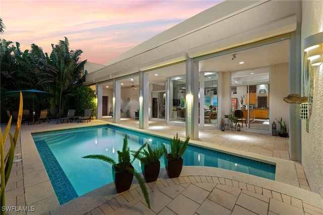 pool at dusk with a patio