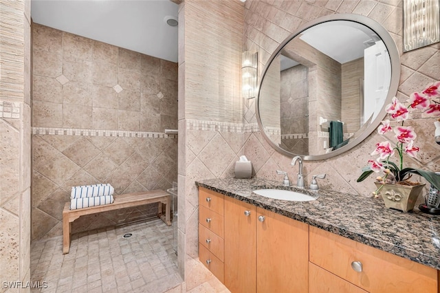 bathroom featuring decorative backsplash, vanity, and tile walls