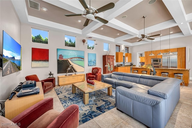 living room featuring coffered ceiling, a towering ceiling, ceiling fan, and beam ceiling