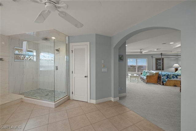 bathroom with tiled shower, ceiling fan, and tile patterned floors