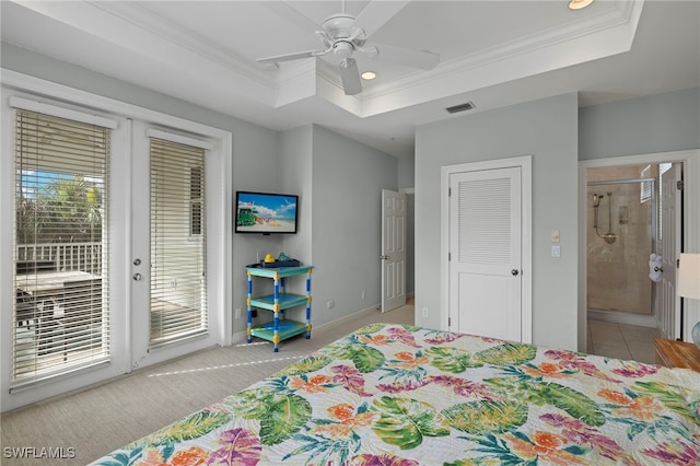 carpeted bedroom featuring ceiling fan, access to exterior, multiple windows, and a tray ceiling