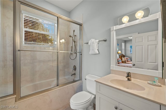 full bathroom with vanity, toilet, and enclosed tub / shower combo