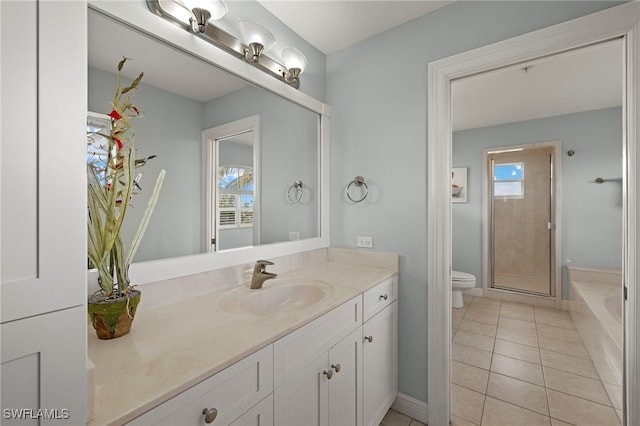 bathroom with a shower with door, toilet, vanity, and tile patterned flooring