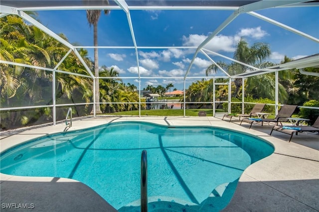 view of swimming pool with a patio area and a lanai