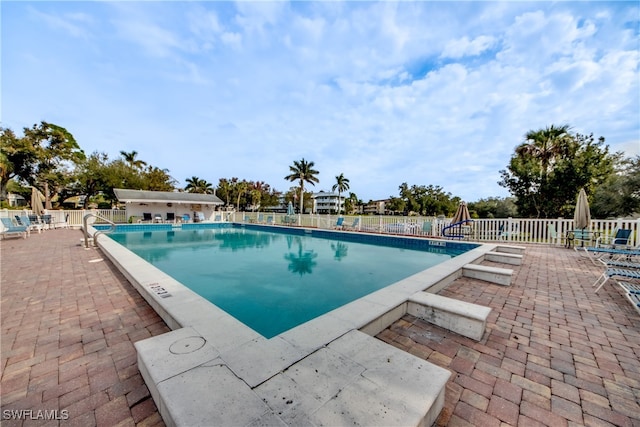 view of swimming pool featuring a patio and a playground