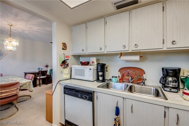 kitchen with light colored carpet, sink, white appliances, hanging light fixtures, and a chandelier