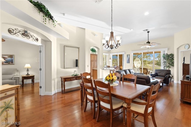 dining area featuring dark wood-type flooring and ceiling fan with notable chandelier