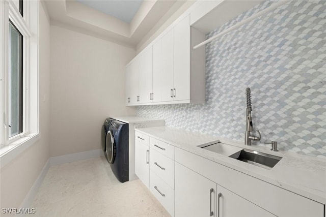 laundry room with sink, washing machine and clothes dryer, and cabinets