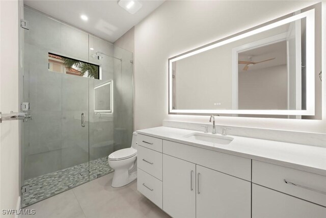 bathroom featuring a shower with shower door, toilet, and vanity