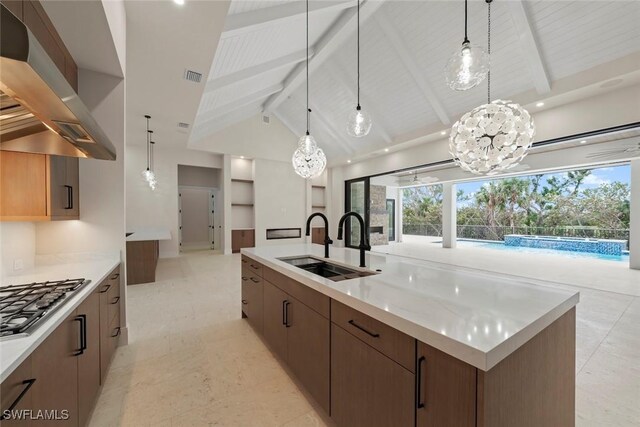 kitchen with a spacious island, decorative light fixtures, sink, wall chimney range hood, and beamed ceiling