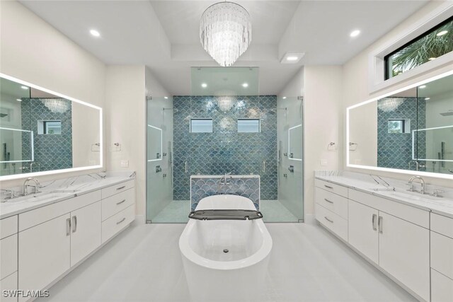 bathroom with vanity, a notable chandelier, and shower with separate bathtub