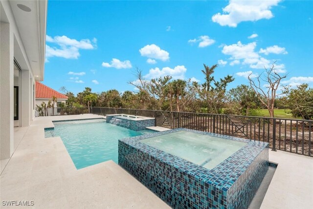 view of pool featuring pool water feature and an in ground hot tub