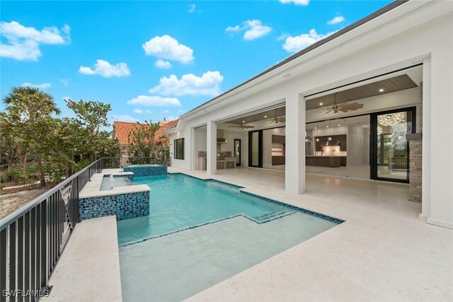 view of swimming pool with an in ground hot tub and ceiling fan