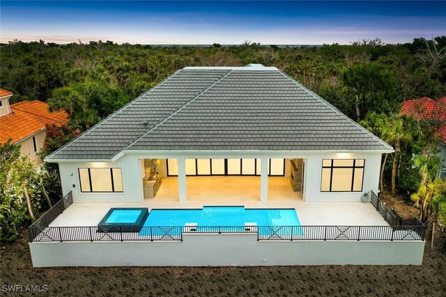 exterior space featuring a patio area and a swimming pool with hot tub