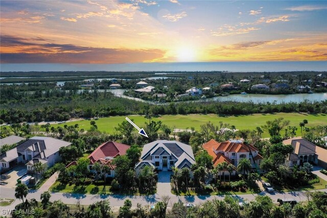 aerial view at dusk featuring a water view