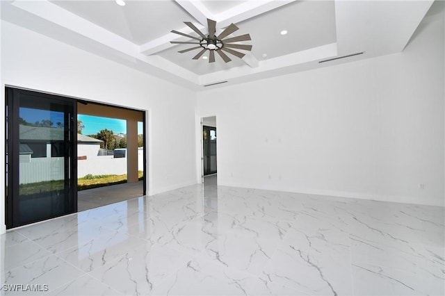 spare room featuring ceiling fan, coffered ceiling, and a tray ceiling