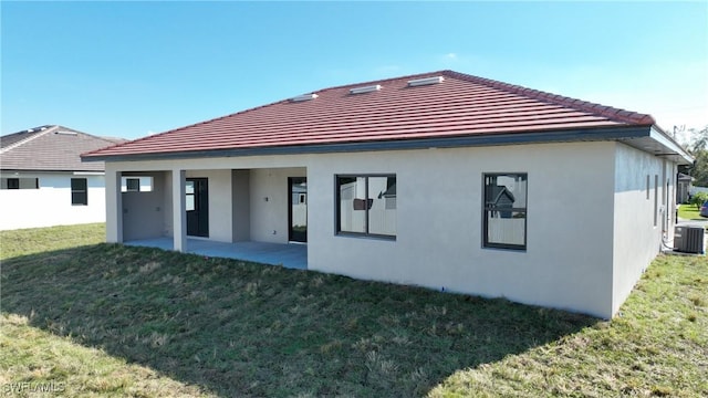 back of property with a patio area, a yard, and central air condition unit